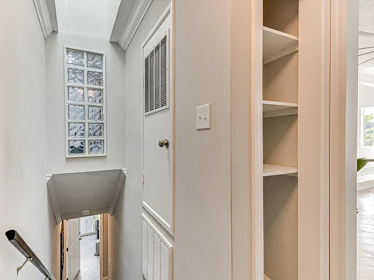 A ground-floor apartment kitchen with white cabinets, dark counters, and a pass-through to the living area