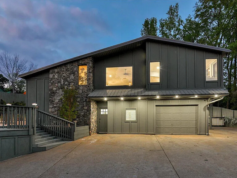 The arched front entrance of the main home: dark glass double doors under a copper awning with a wall lantern