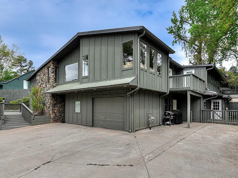 The main home at 2417 Wilkshire Drive seen from the driveway, with the deck rail above the garage