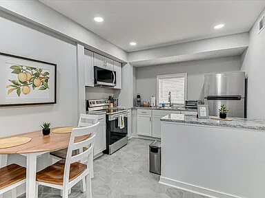 The in-unit laundry facility with a full-size washer and dryer against marble-look tile