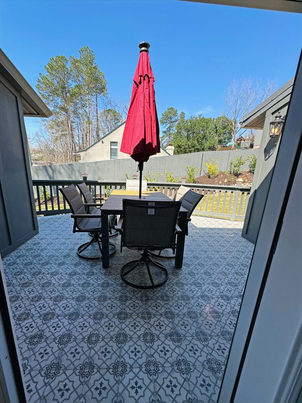 The Magnolia's tile patio with patterned tile underfoot, a table and chairs, and a red umbrella