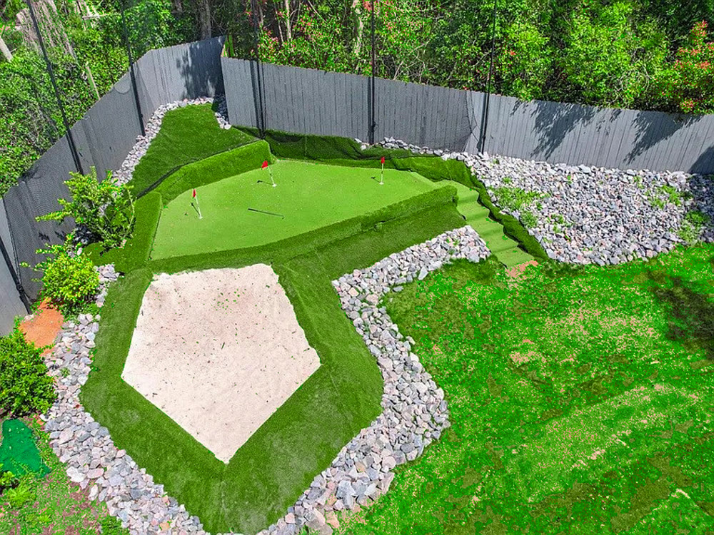 The private putting green from above: synthetic turf with several flagged holes and a sand trap